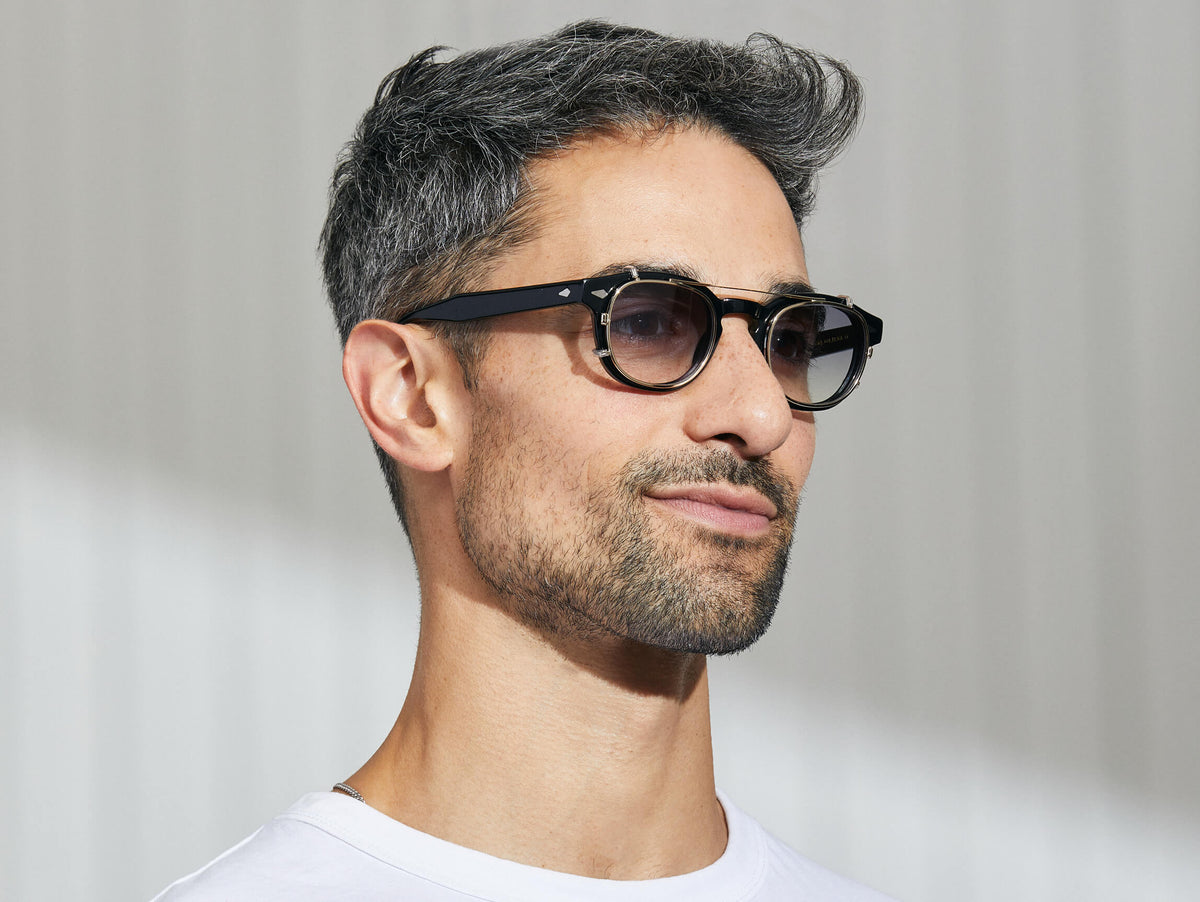 El modelo lleva puesto el CLIPTOSH in Gold en talla 46 con lentes tintados American Grey Fade.