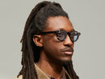 Model is wearing The DOLT CLIP in Gold in size 46 with Bel Air Blue Tinted Lenses