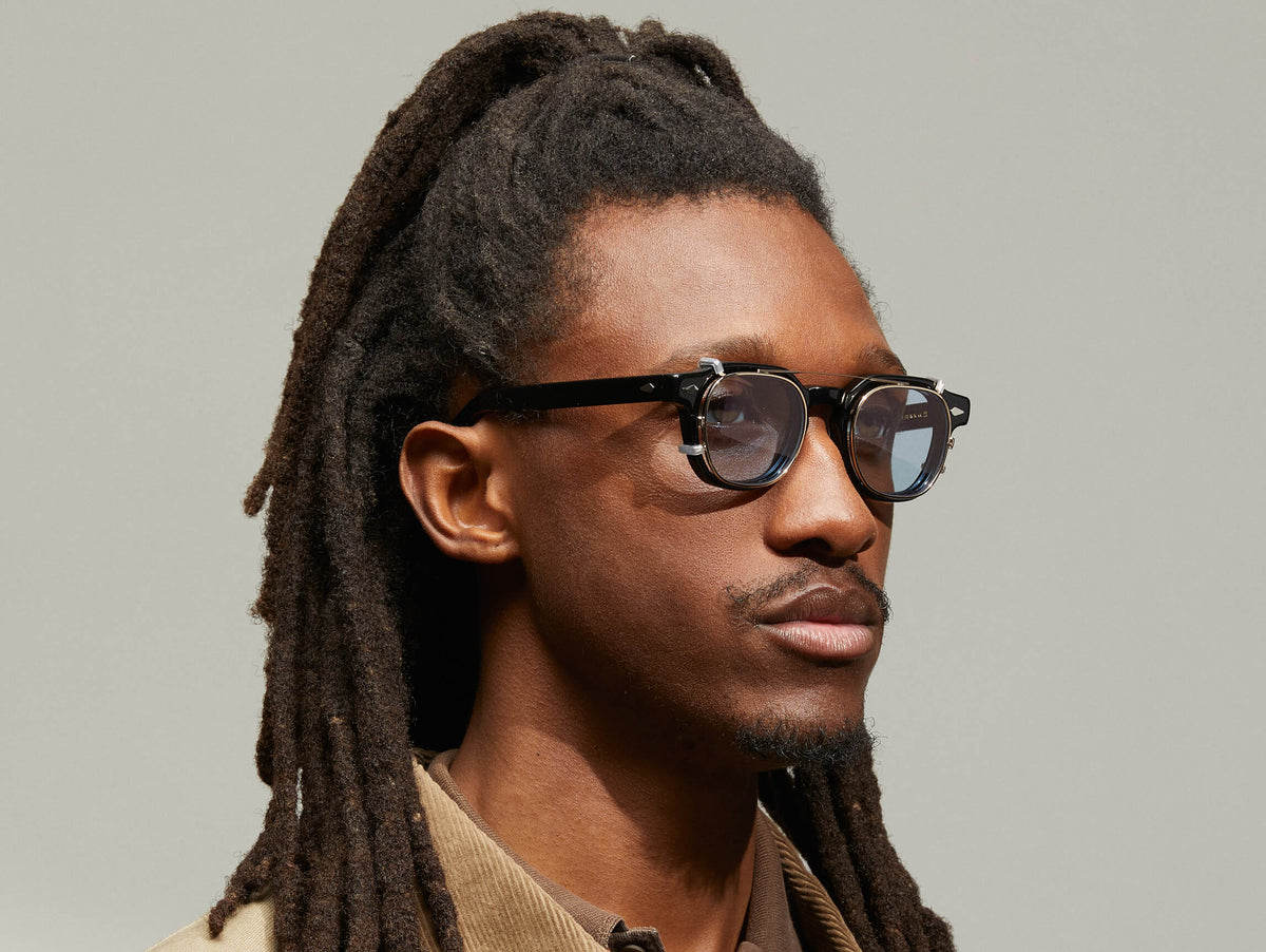 Model is wearing The DOLT CLIP in Gold in size 46 with Bel Air Blue Tinted Lenses