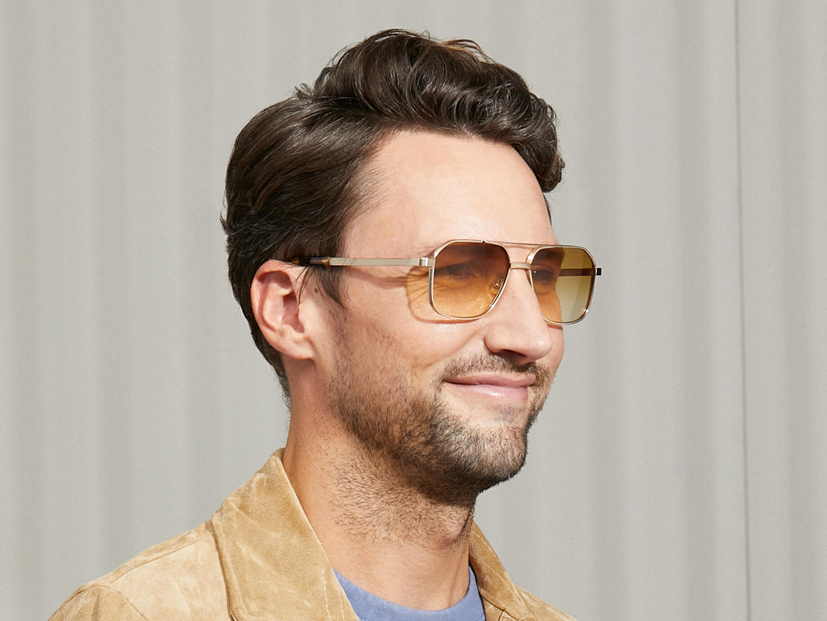 Das Modell trägt die MINGLE SUN in Gold in Größe 57 mit Chestnut Fade getönten Gläsern.