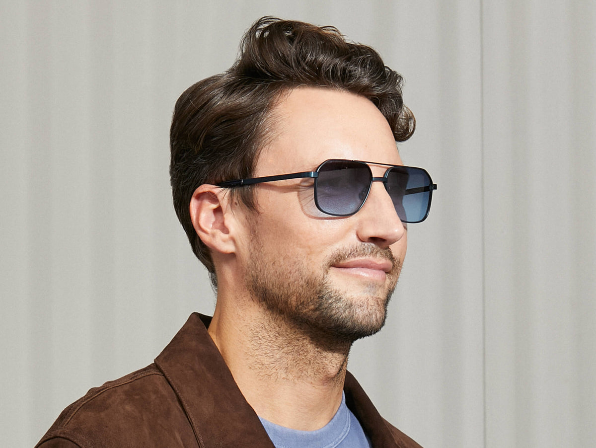 Das Model trägt die MINGLE SUN in Navy in Größe 57 mit Denim Blue getönten Gläsern.