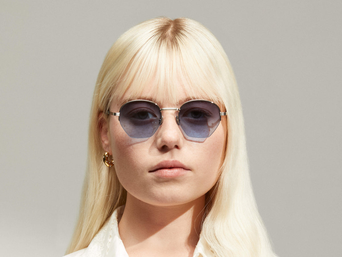 النموذج يرتدي PLOTZ SUN بمقاس 49 بلون Silver مع عدسات ملونة Denim Blue