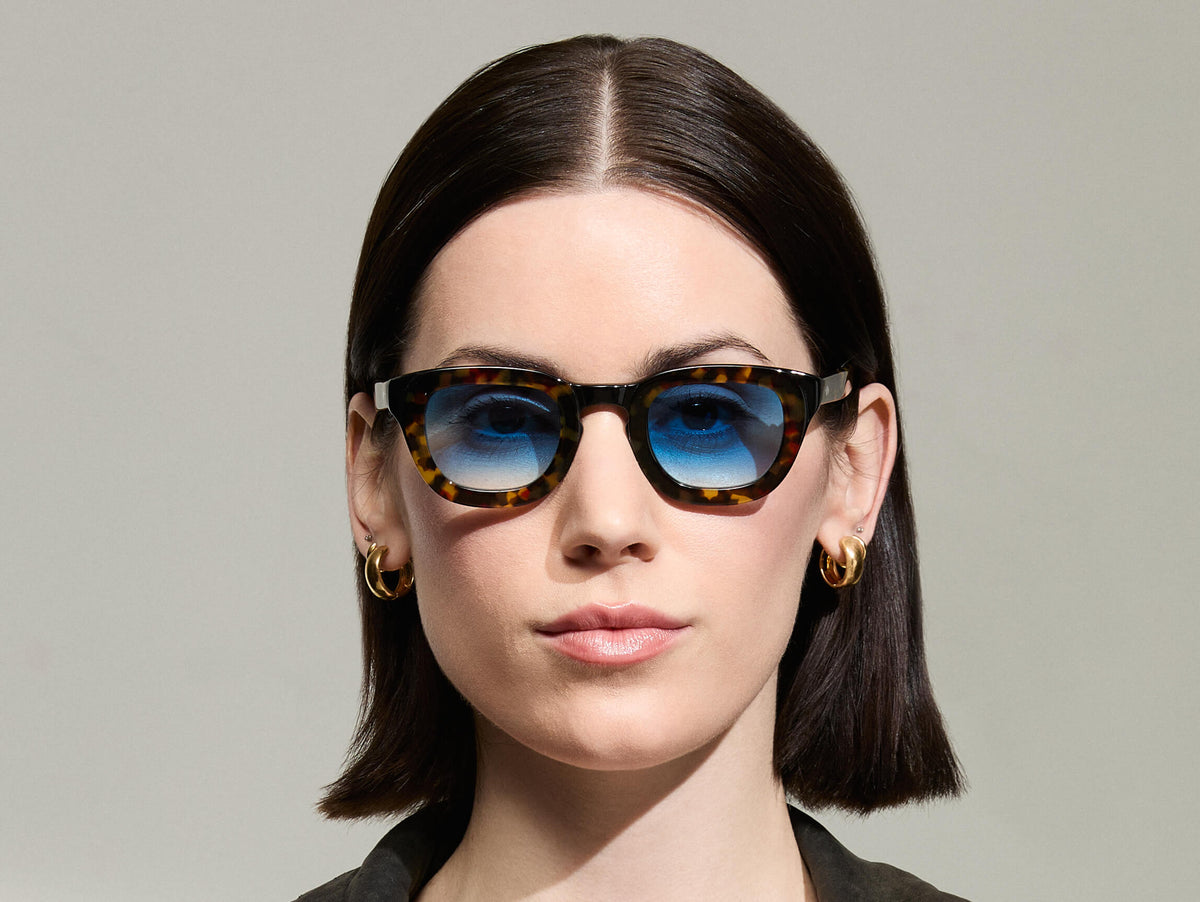 Model is wearing The TELENA  in Tortoise/Black in size 44 with Broadway Blue Tinted Lenses