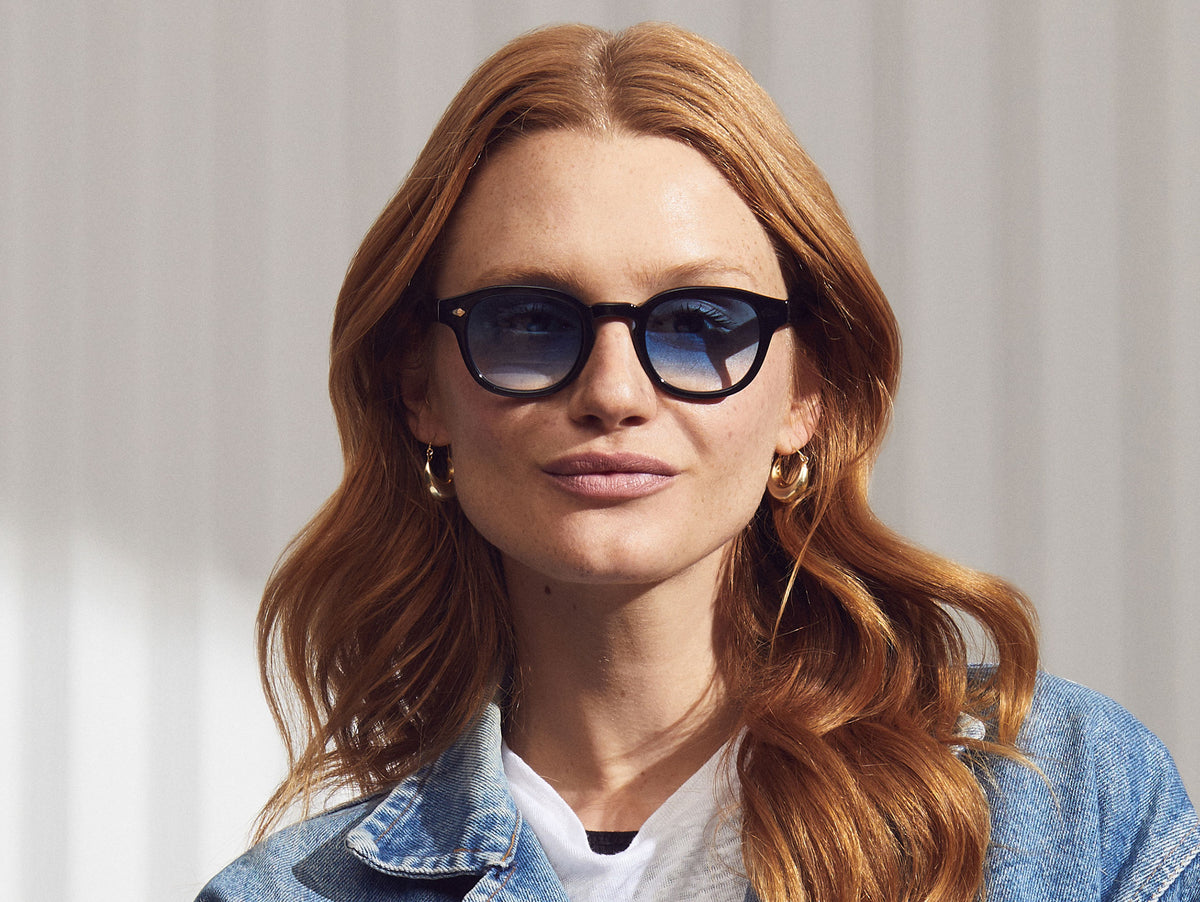 El modelo lleva The LEMTOSH in Black en talla 49 con lentes tintados Broadway Blue Fade.